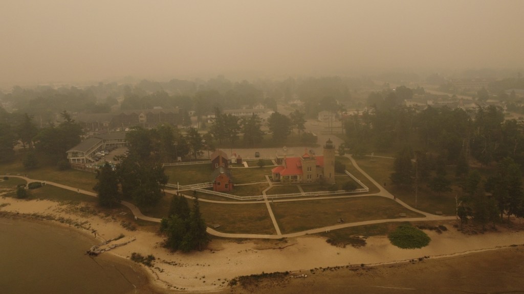 Aerial shot of Old Mackinac Point Lighthouse surrounded in smoke. Captured by drone.