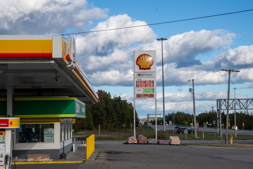 Side view of a gas station with the price sign visible showing the price of both unleaded and diesel 